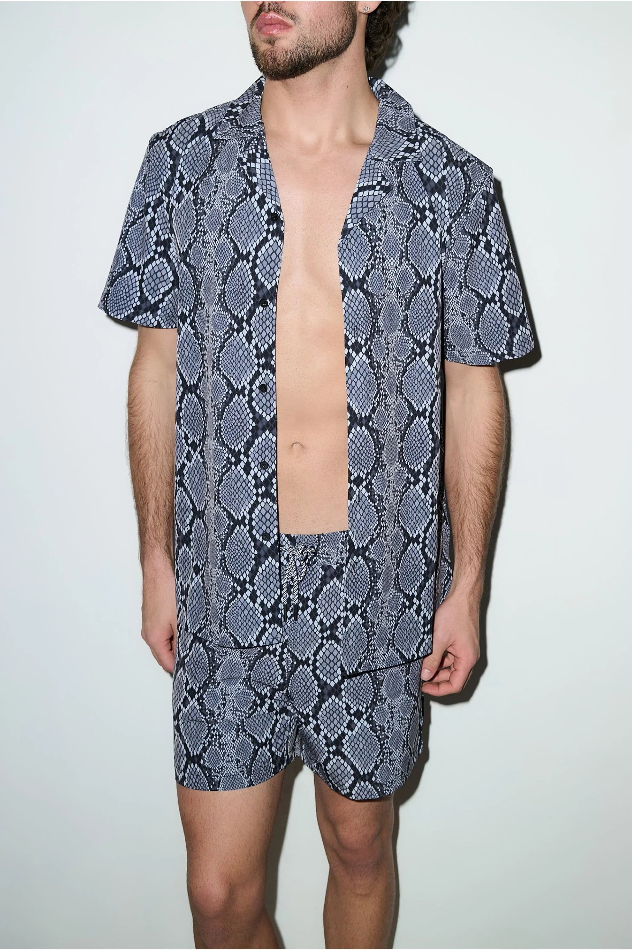 Man wearing matching snake print cabana shirt and swim shorts set, short sleeves, modern fit