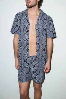 Man wearing matching snake print cabana shirt and swim shorts set, short sleeves, modern fit